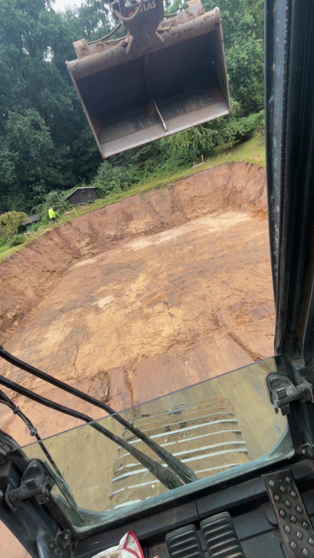 Fertig ausgehobene Baugrube mit ebenem Planum aus der Baggerkabine