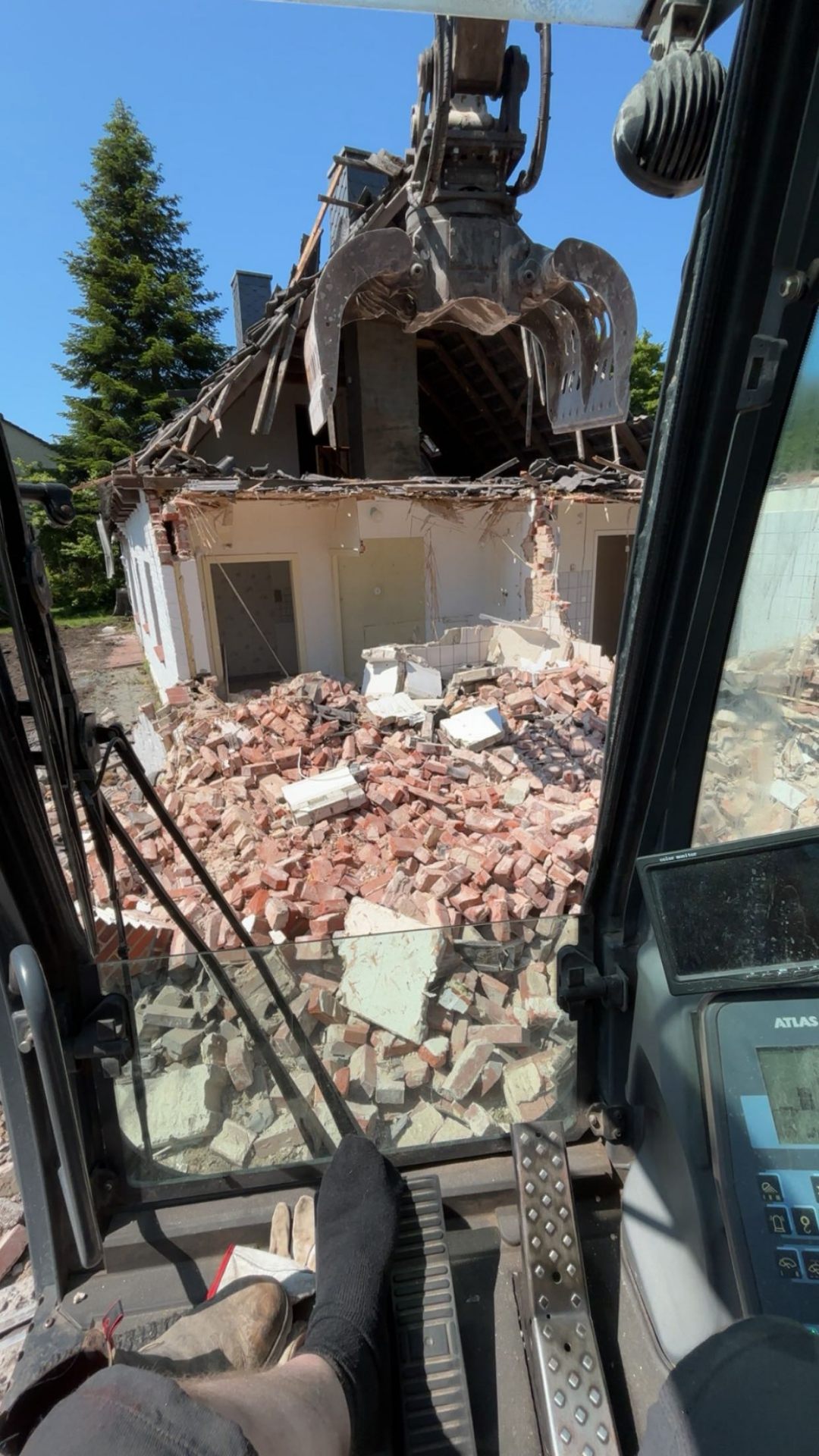 Abbrucharbeiten an einem Einfamilienhaus — Blick aus der Baggerkabine